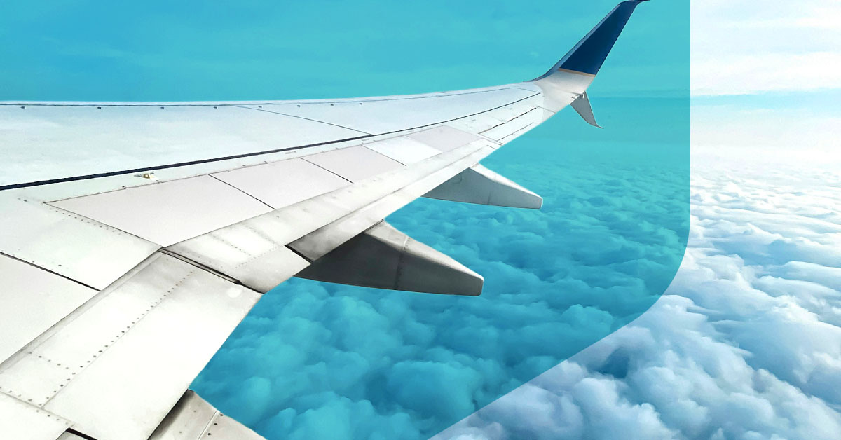 Aircraft wing over cloudy sky.