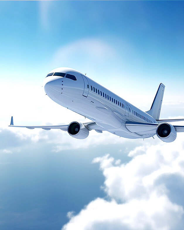 Airplane flying over clouds in a blue sky.