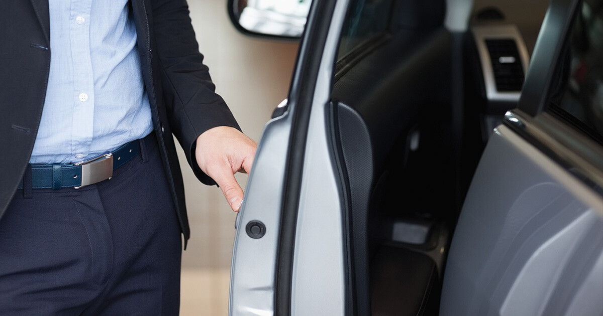 Man opening door of a car, showing the rubber sealing of the door.